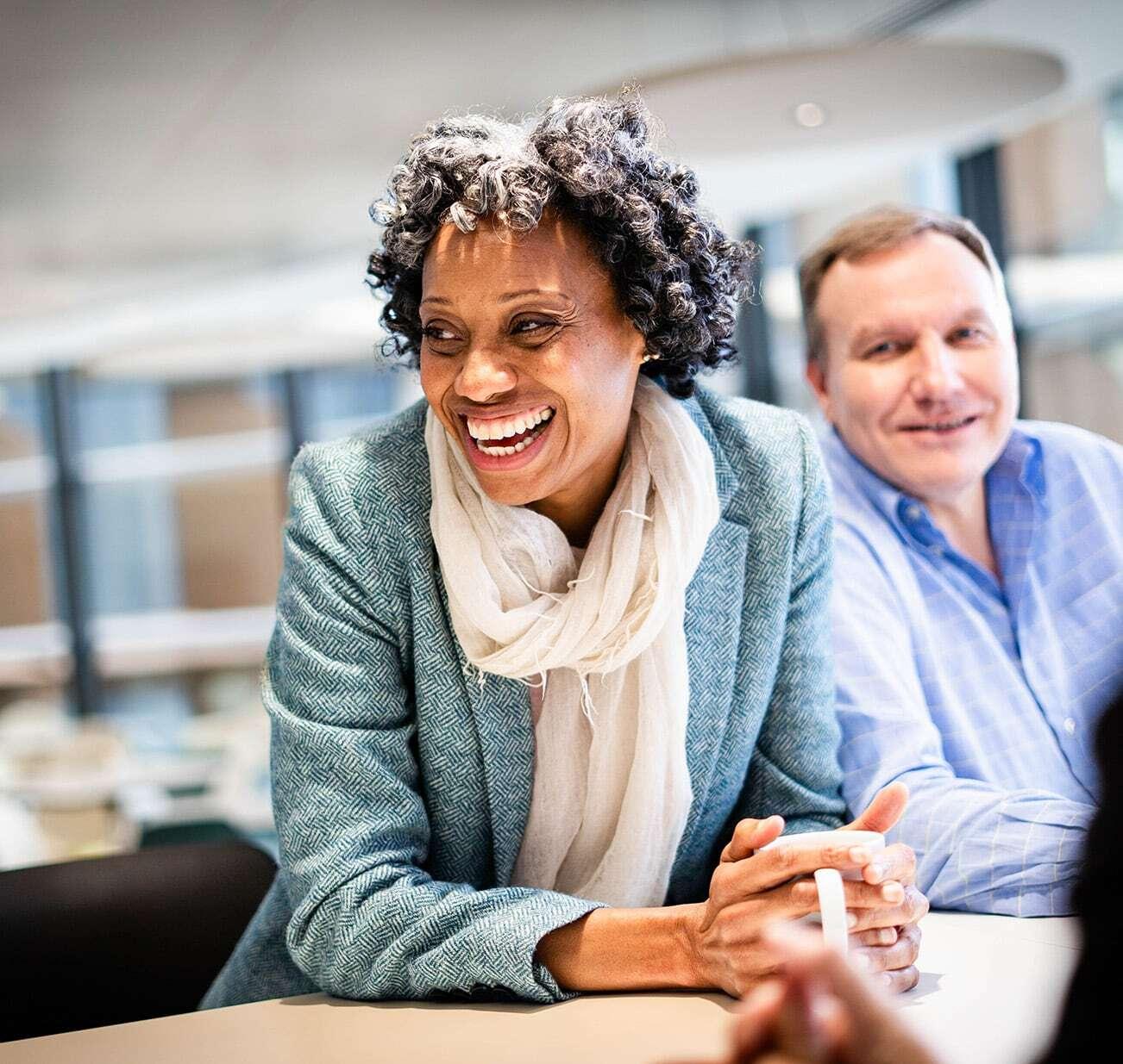 Two people smiling within an office.