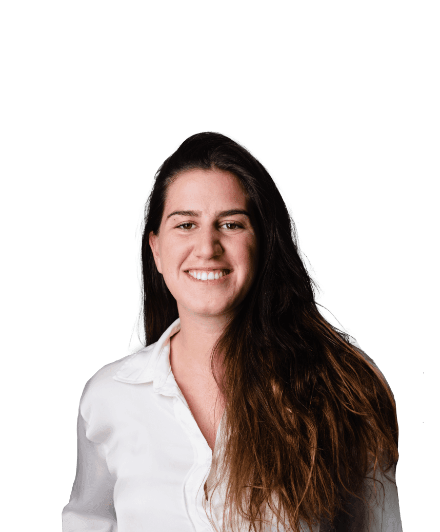 A woman smiles wearing a white shirt in front of a blurred background.