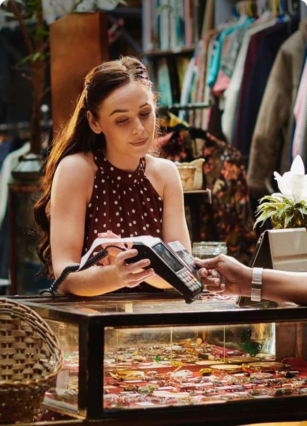 Women taking a card payment in a shop.