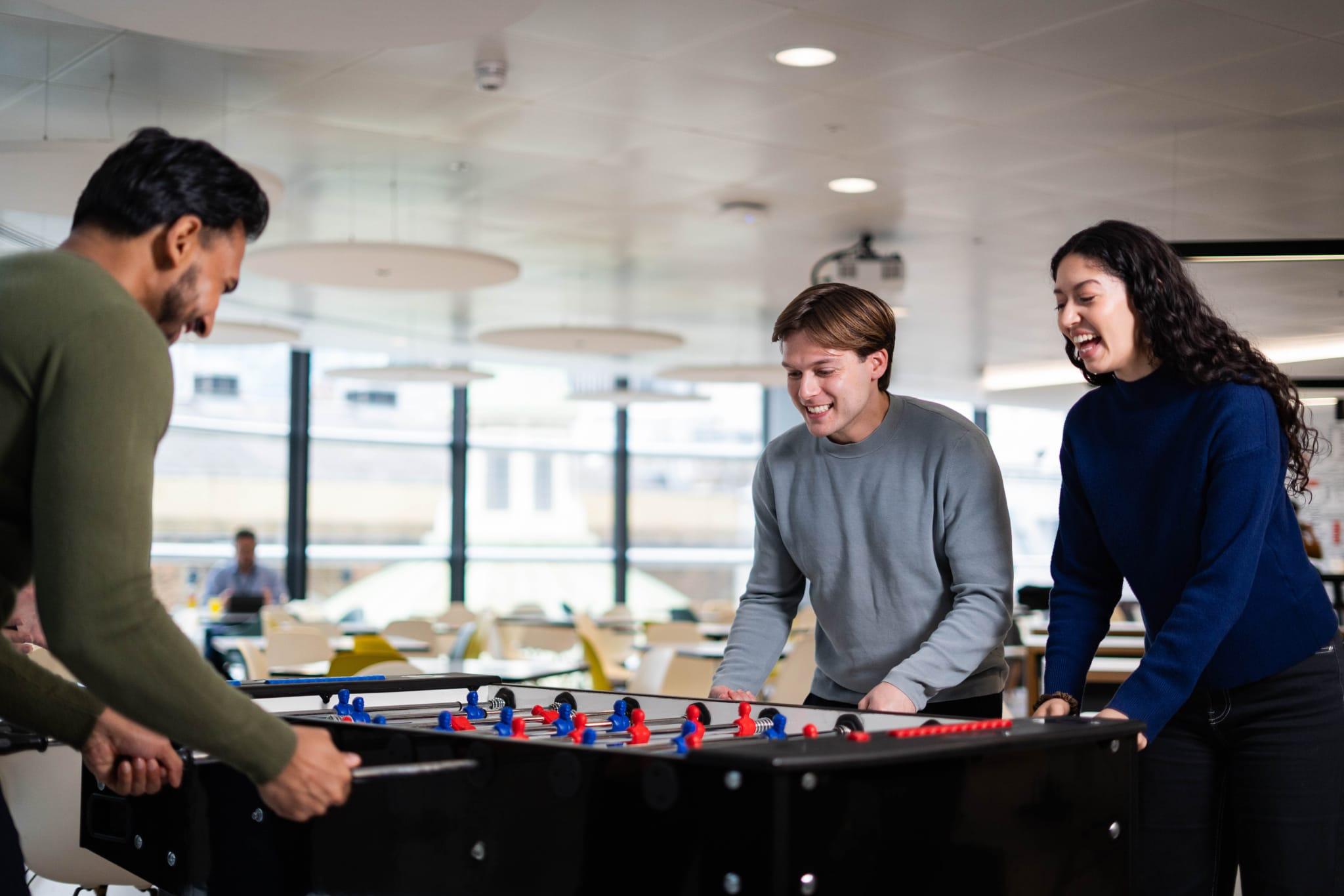 Team members playing table football.