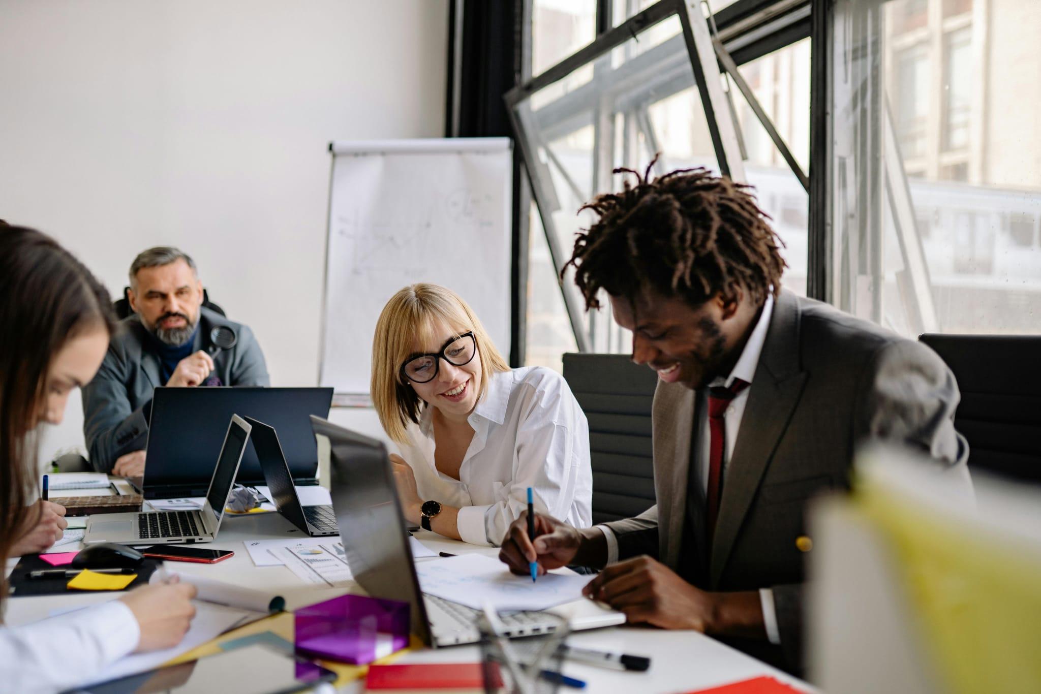 A diverse group of people on an office working around a table.