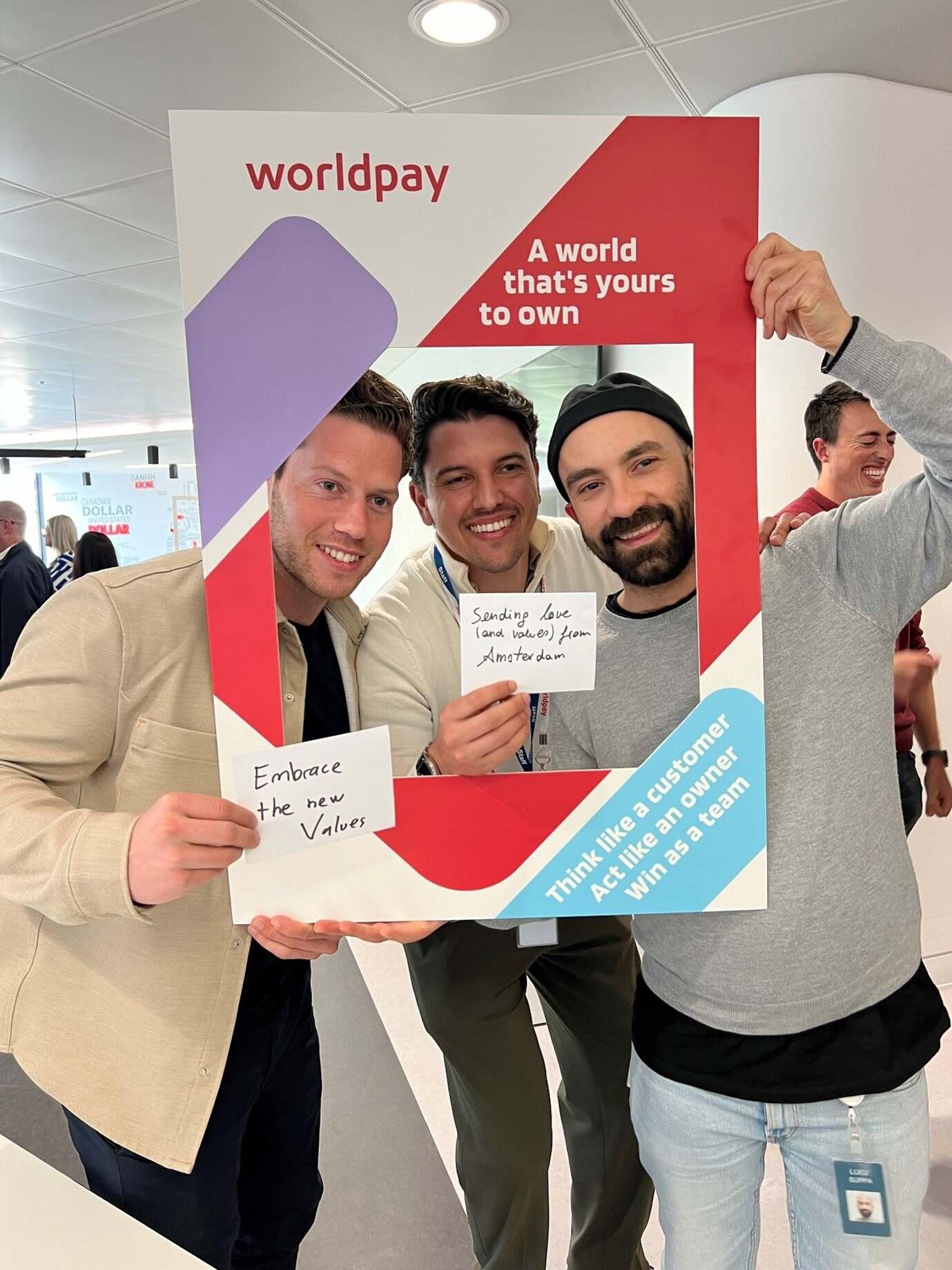 Worldpay employees holding up branding signage