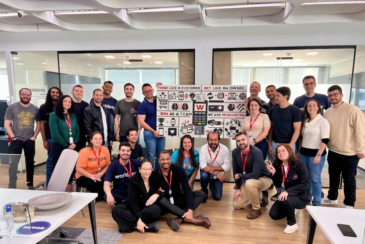 Group photo of Manchester team around their Lego Mural wall