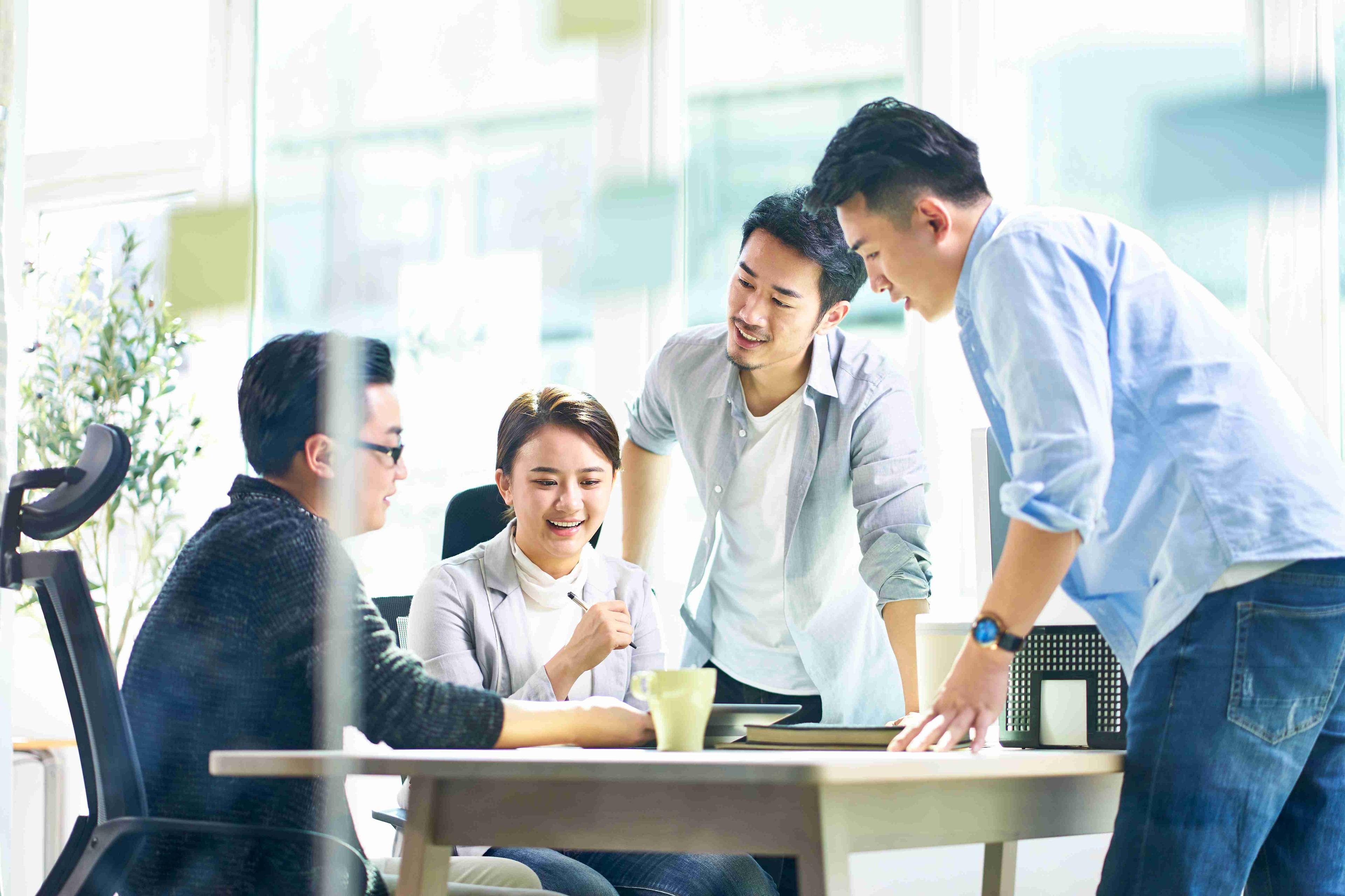 Group of men and women working in an office together