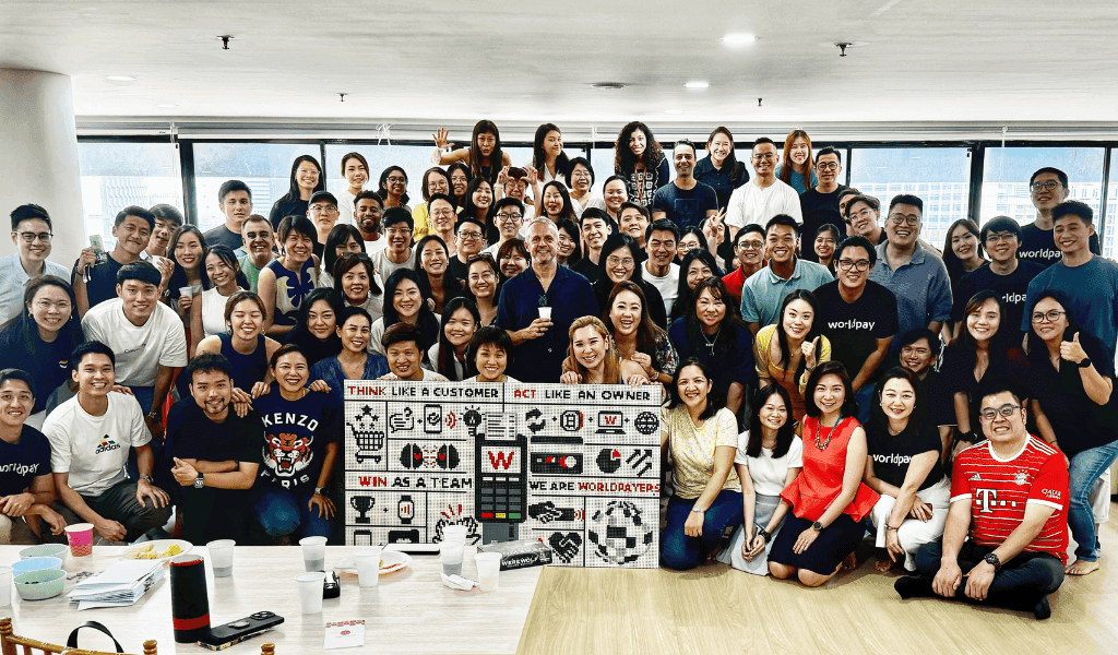 Large group gathered around Lego mural in Worldpay office