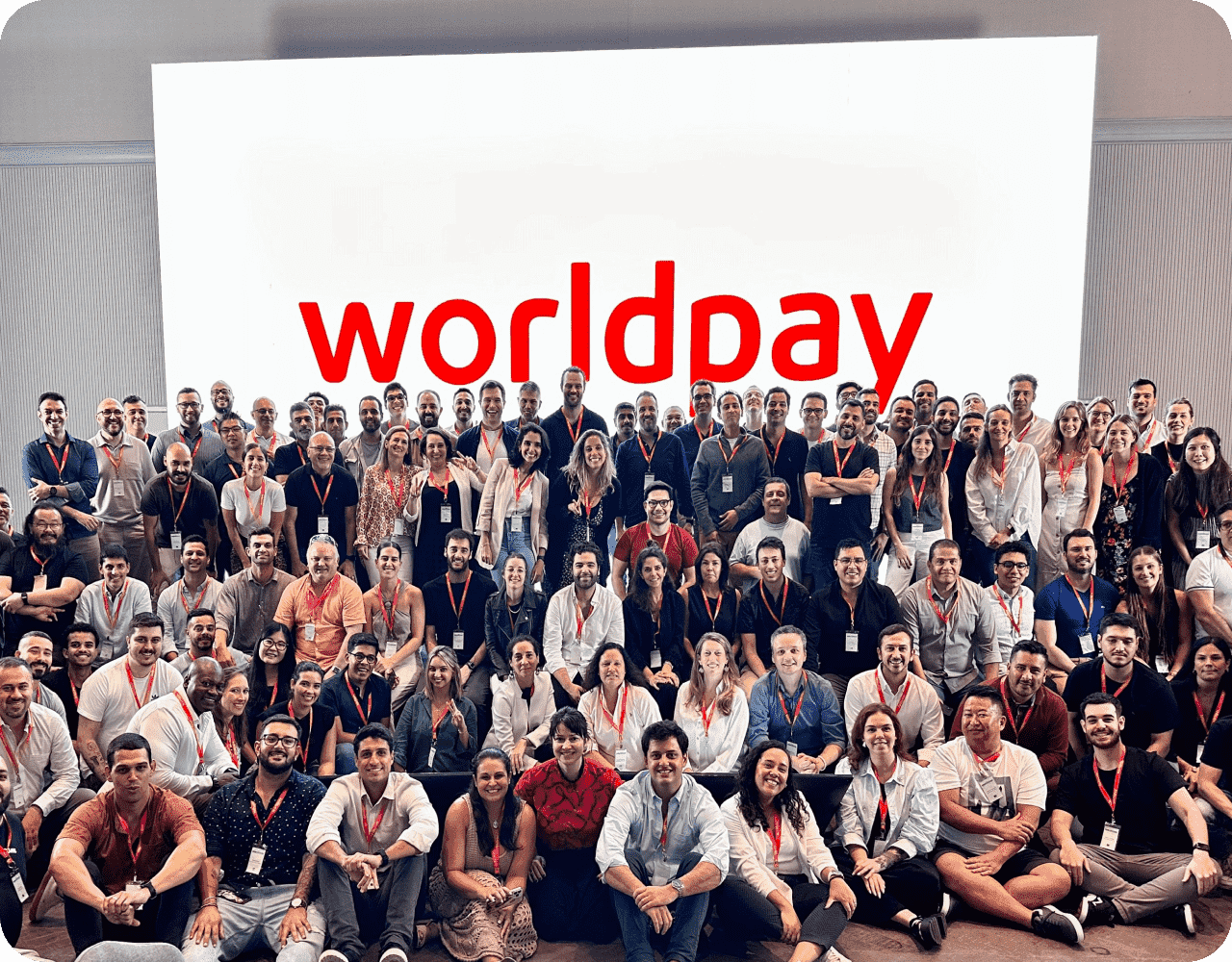 Big group of people in front of white and red sign