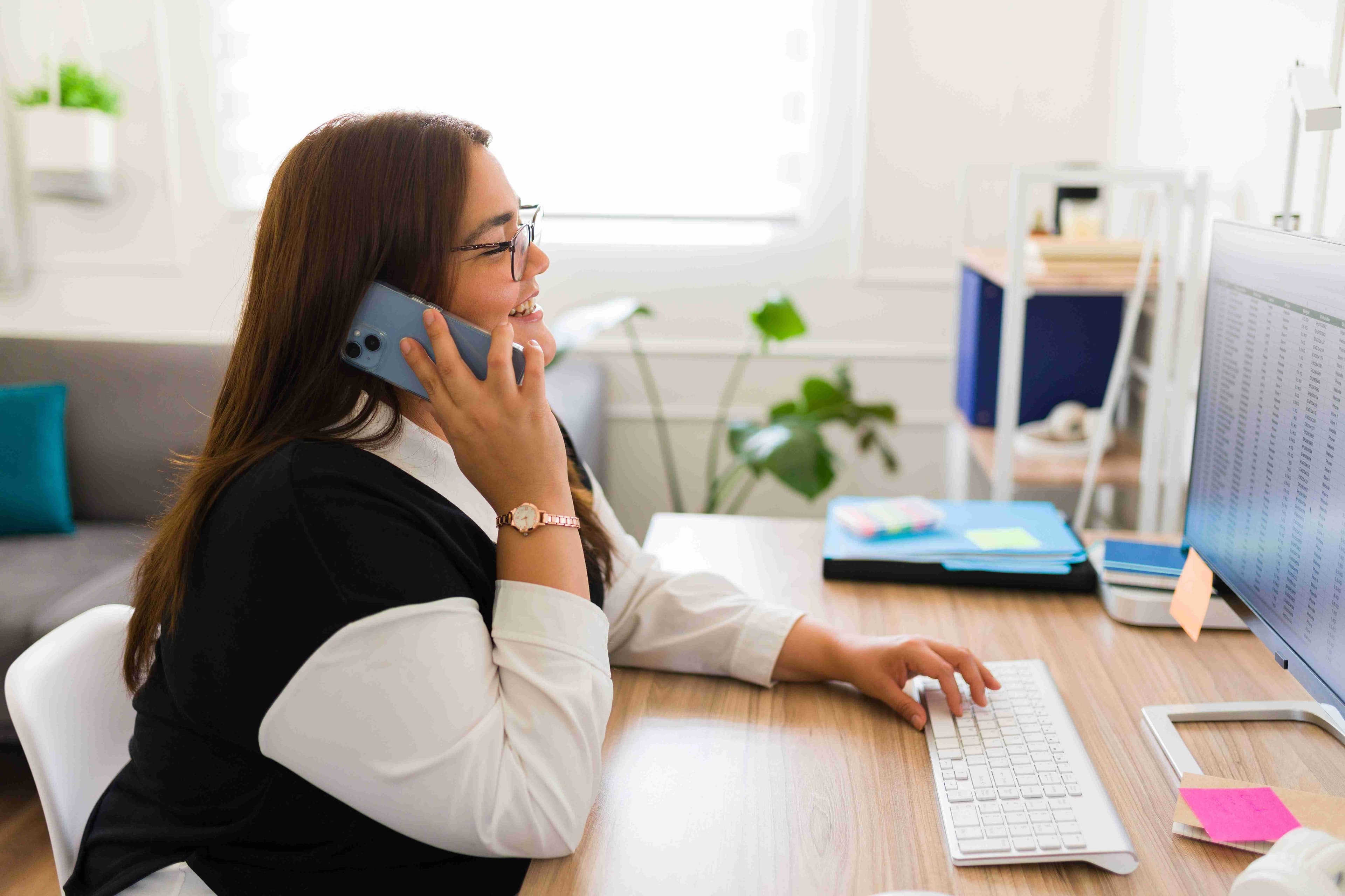 Woman in white shirt and black top holding phone
