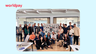 group of colleagues together with lego wall behind