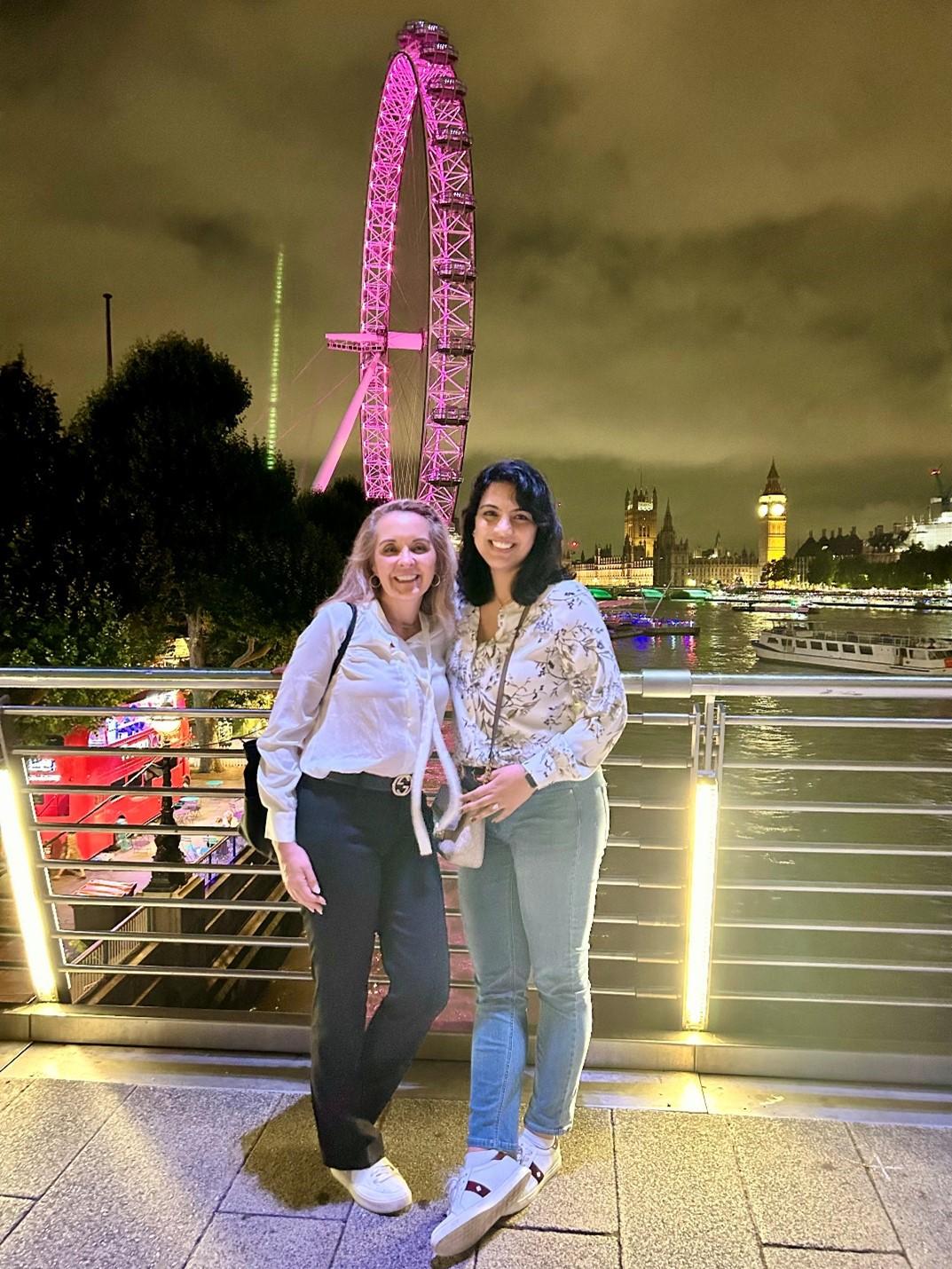 two women with ferris wheel behind